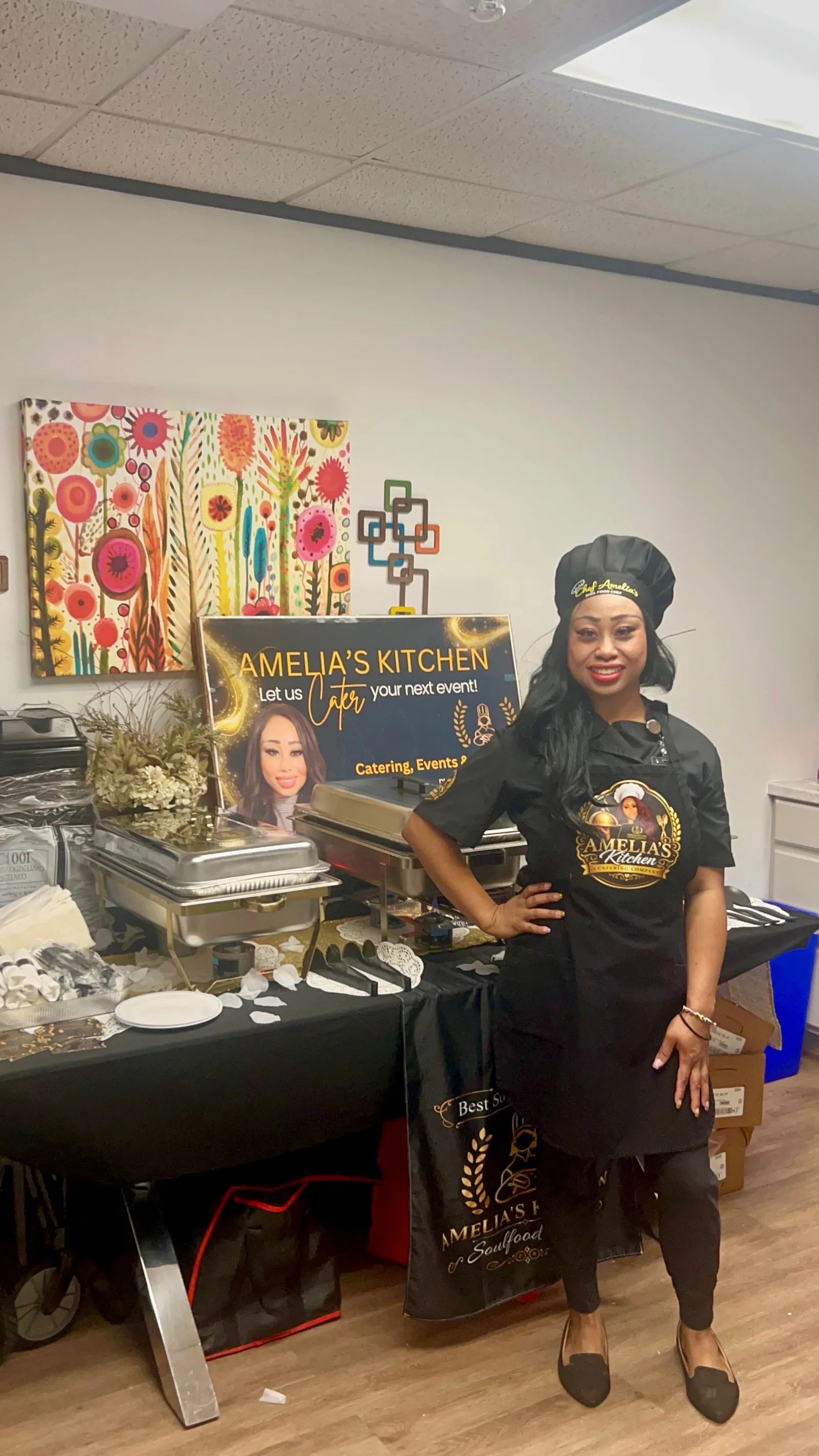 Chef Amelia standing beside food trays at a catering setup