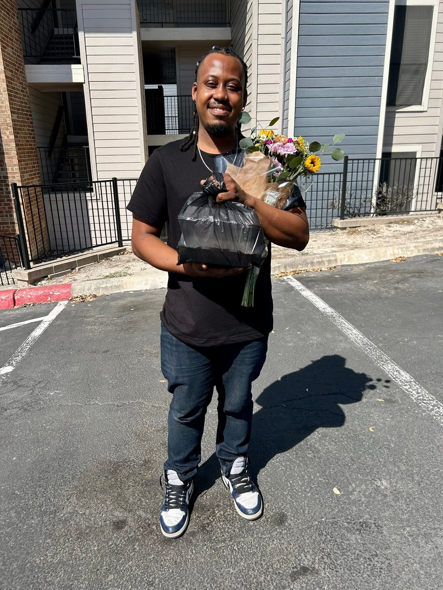 A guest holding a thank-you bouquet and a catering order at Customer Appreciation Day