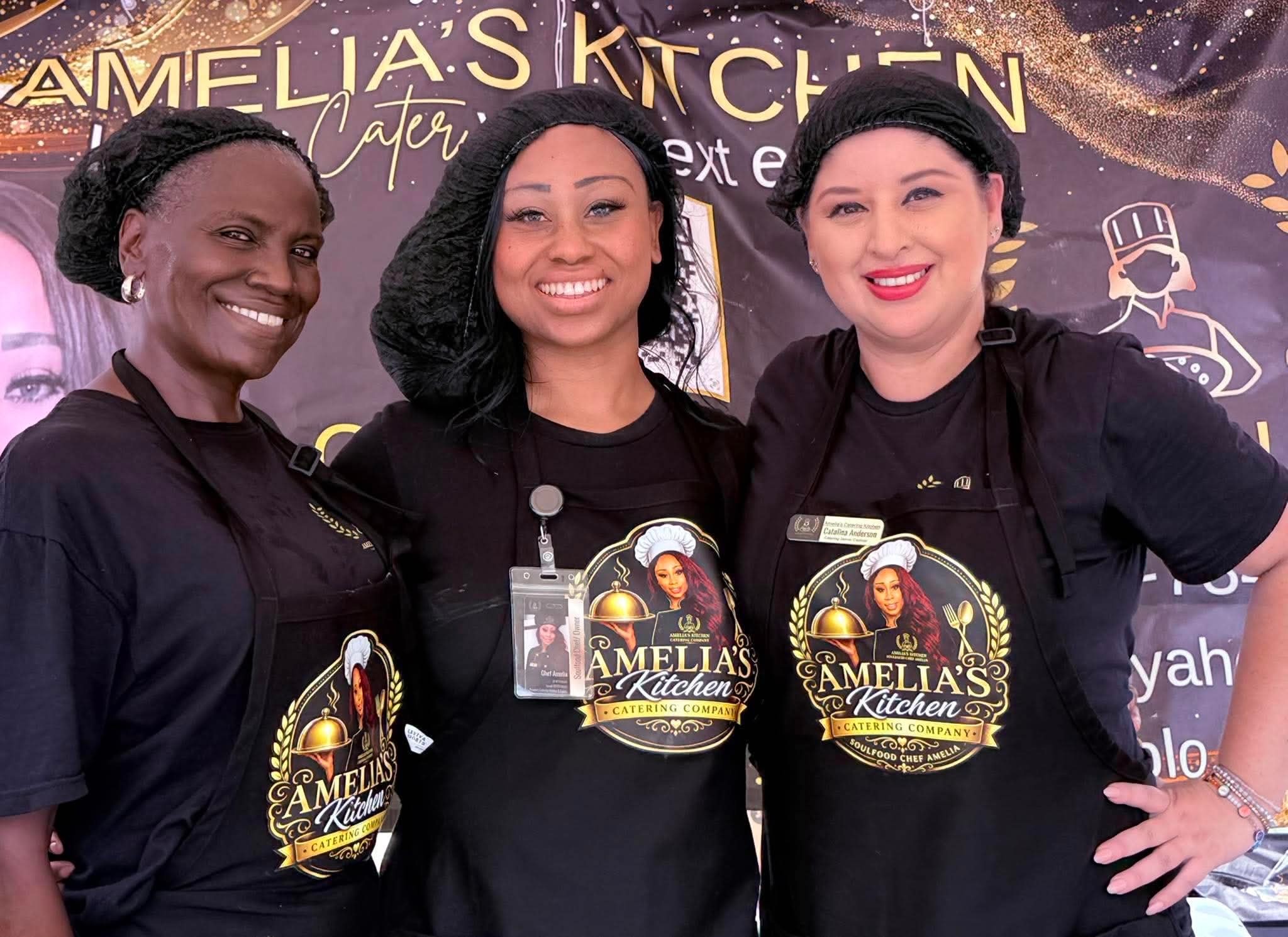 Three Amelia's Kitchen staff members in branded shirts at an event