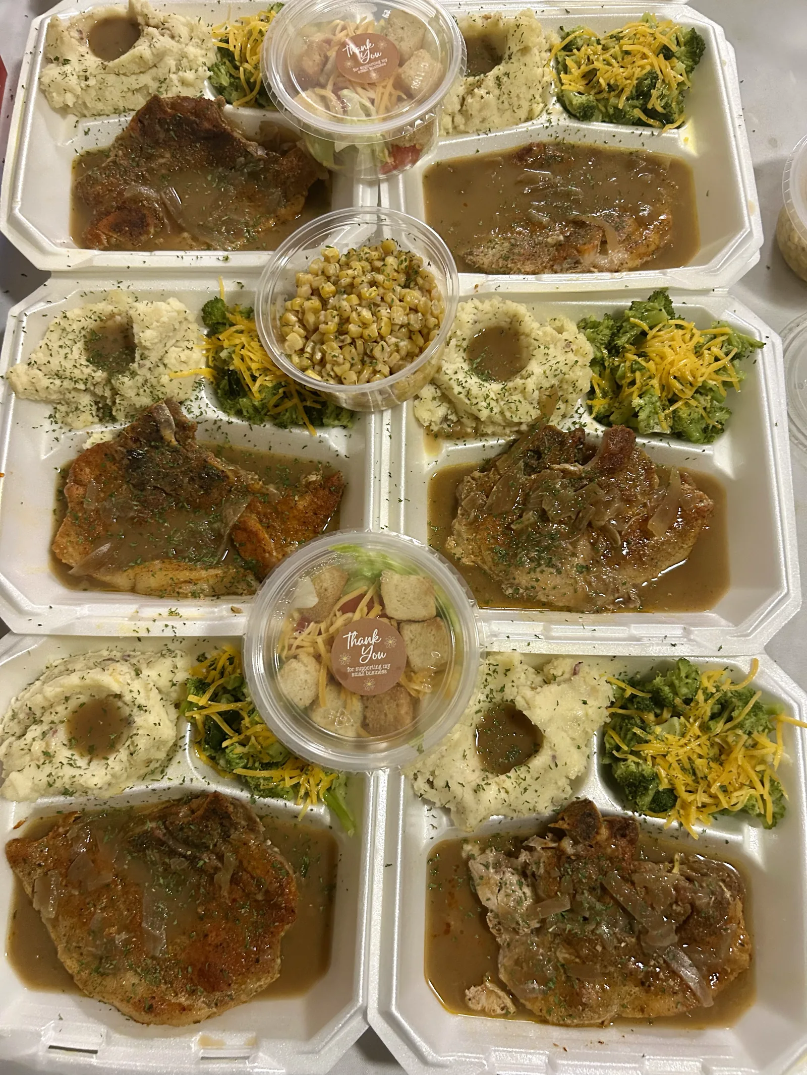 Smothered pork chops with rice, greens, and corn