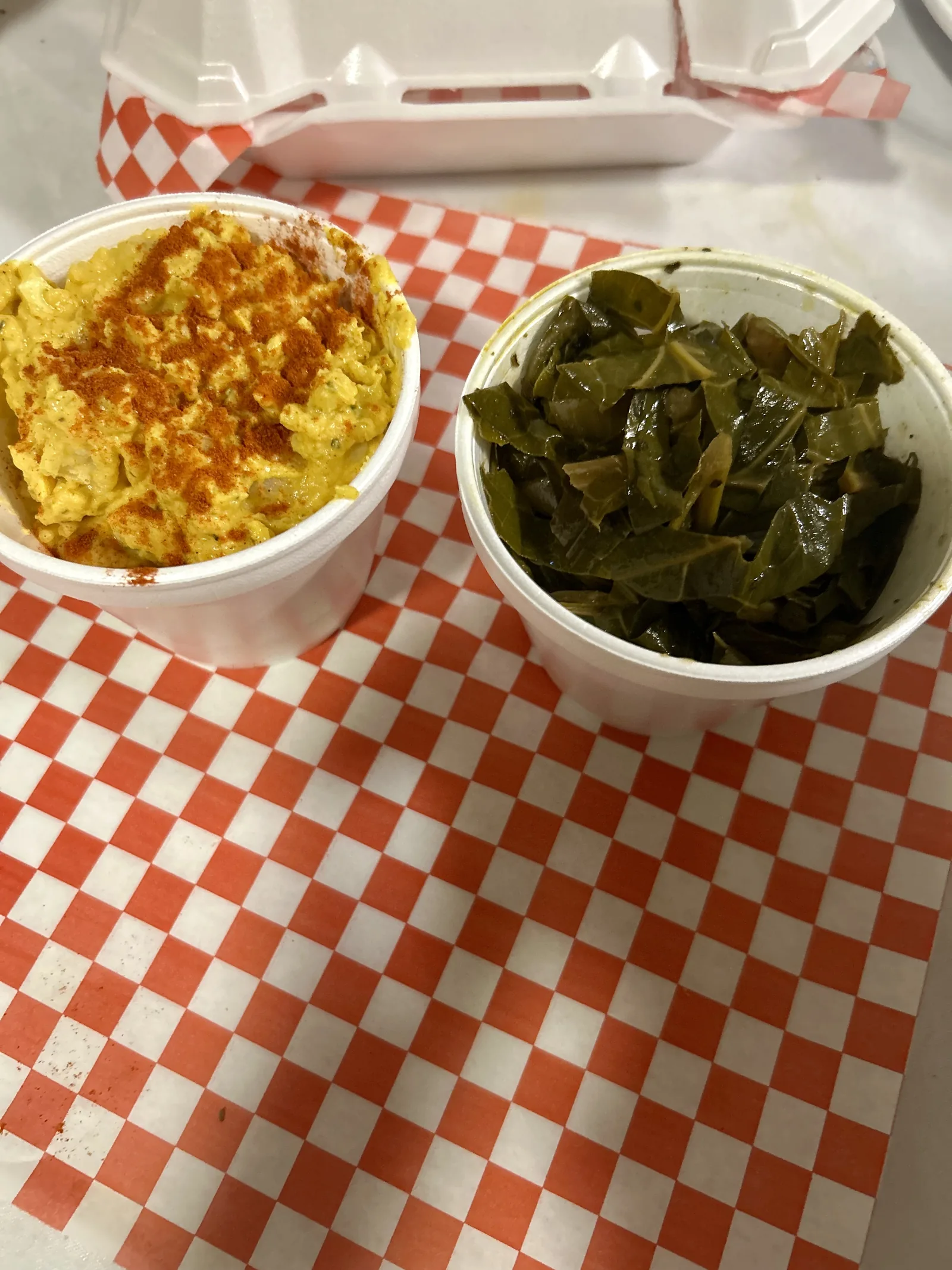 Mac and cheese and collard greens in takeout cups